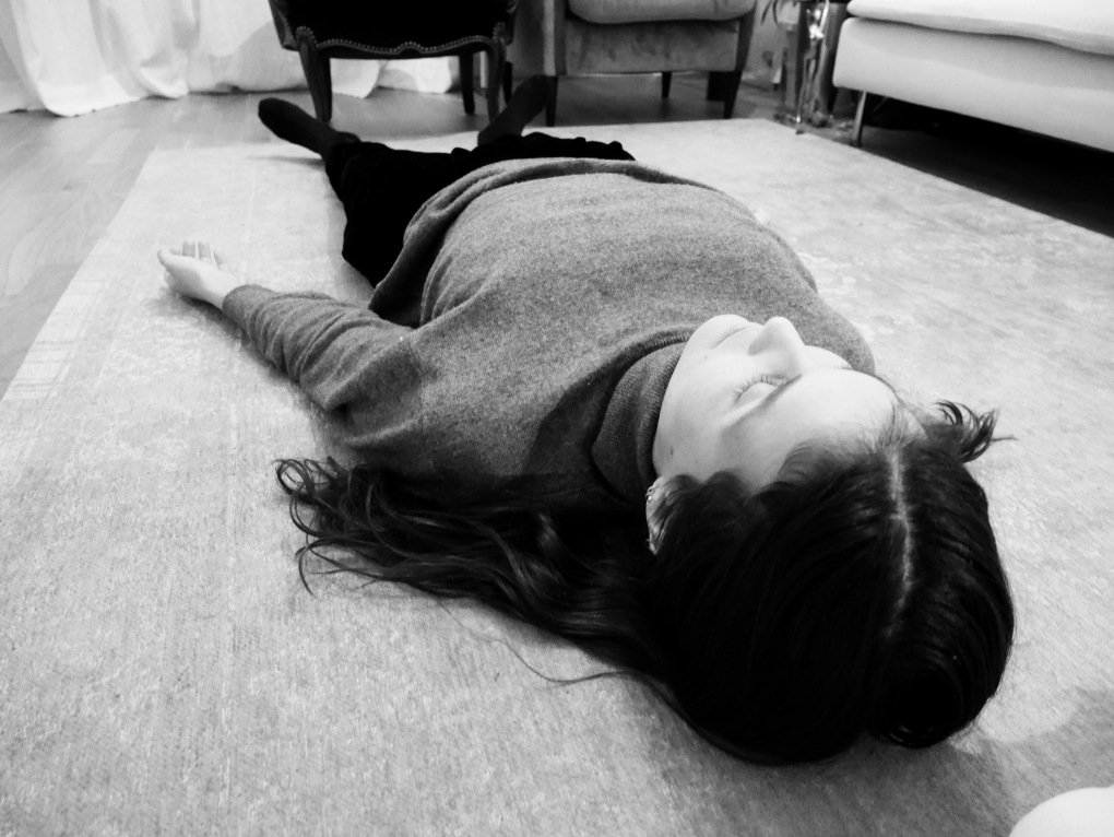 Mulher deitada no chão praticando treino autógeno