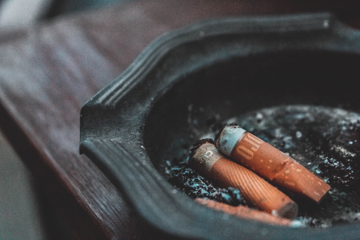 Três bitucas de cigarro dentro de um cinzeiro