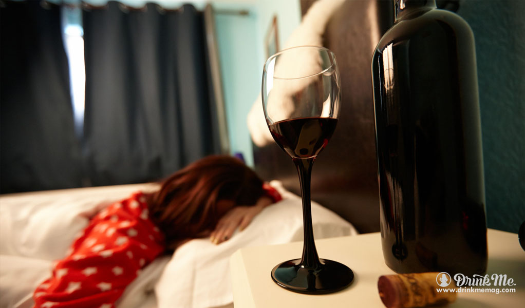 Taça de vinho com mulher dormindo atrás